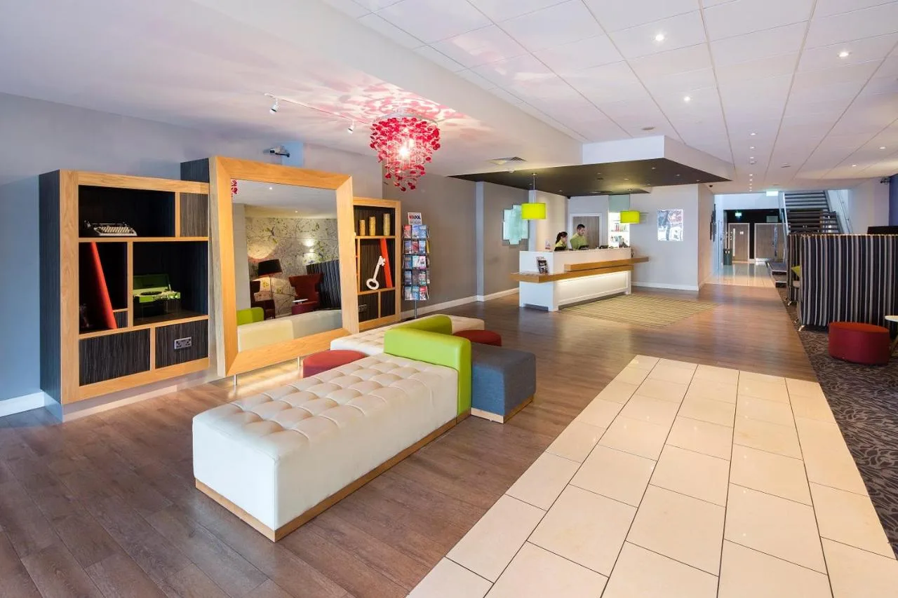 A living room with a couch and a chandelier at Holiday Inn Liverpool City Centre by IHG in Liverpool