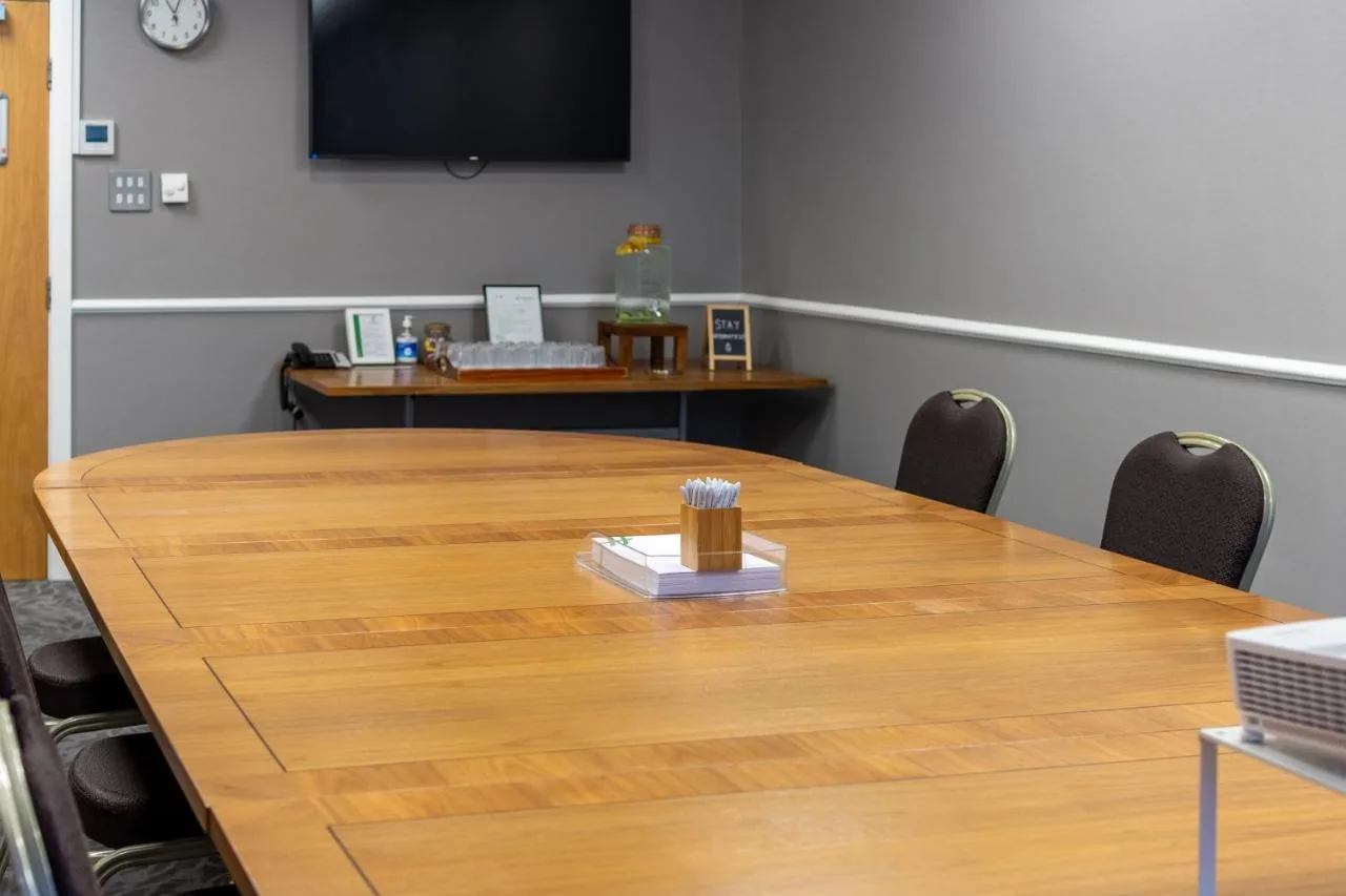 A conference room with a large wooden table with chairs at Holiday Inn Liverpool City Centre by IHG in Liverpool